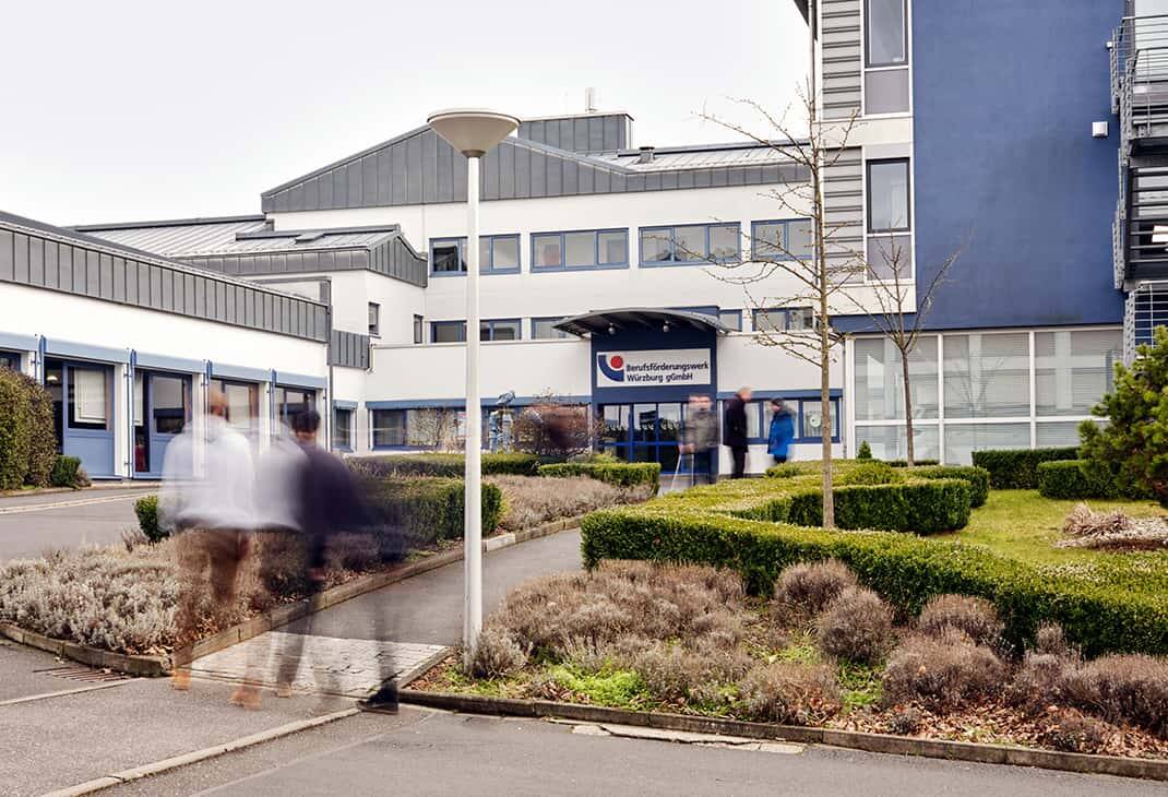 Student activity in front of the BFW Würzburg building entrance.